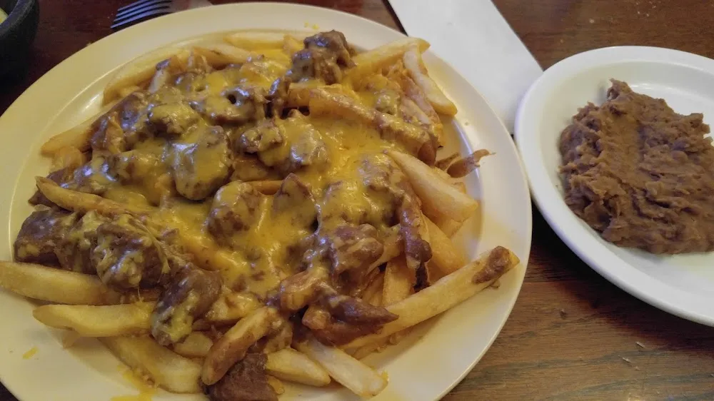 French Fries Topped with Guisado and a Side of Beans